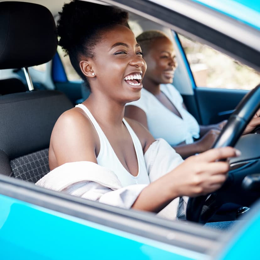 Two friends laughing on a road trip