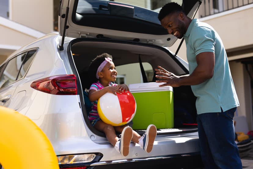 Father and daughter unloading the trunk of their rented car