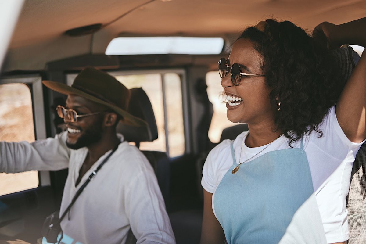 Road trip, driving and black couple drive to travel on a summer vacation with a smile. Happy girlfr by YuriArcursPeopleimages