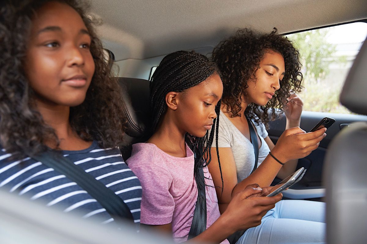 Teenage Children Using Digital Devices On Family Road Trip by monkeybusiness