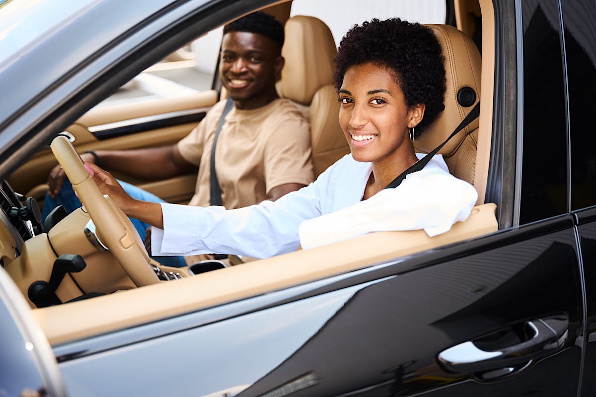 Smiling Woman Driving Car with Passenger by svitlanah