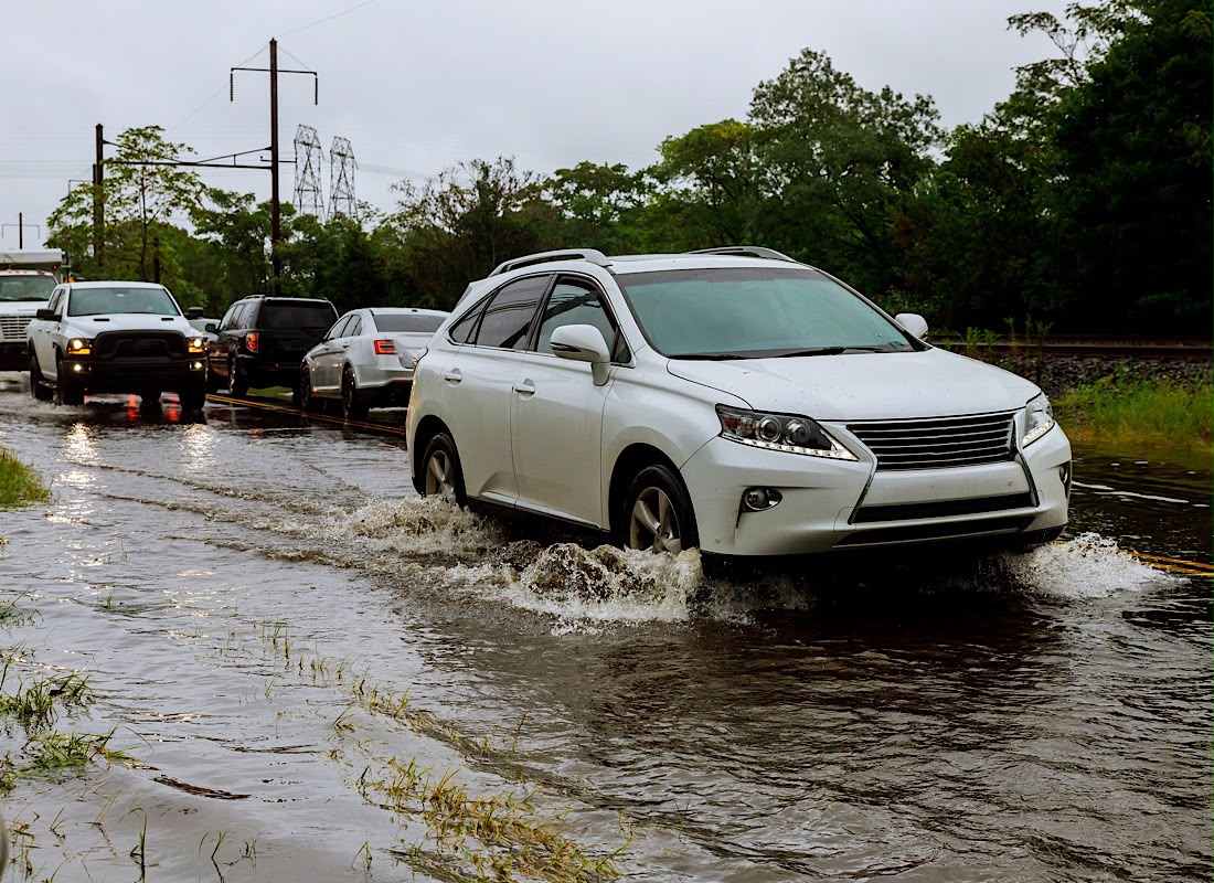 Cars driving on a flooded road during a by heavy rain, by photovs