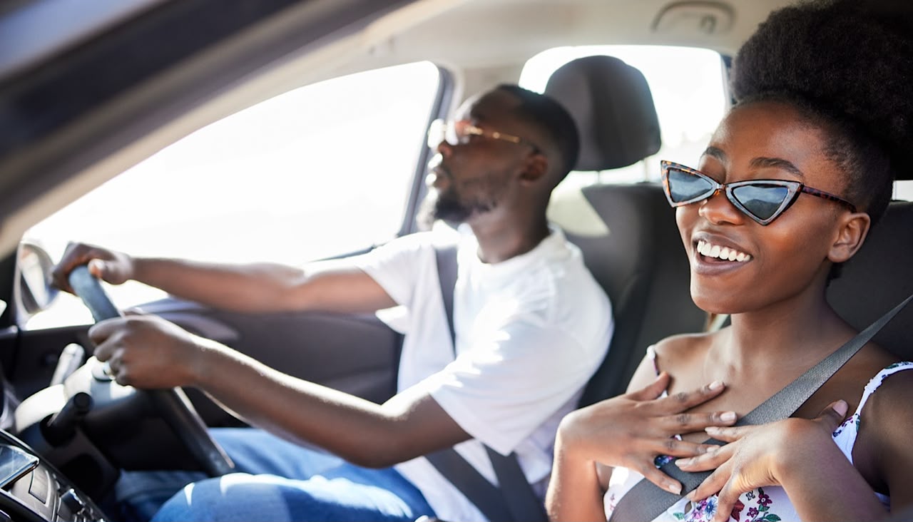 Woman Smiling in Car with Man Driving by YuriArcursPeopleimages